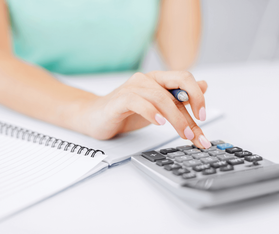 close up of a Calculator on a desk with a hand typing on it